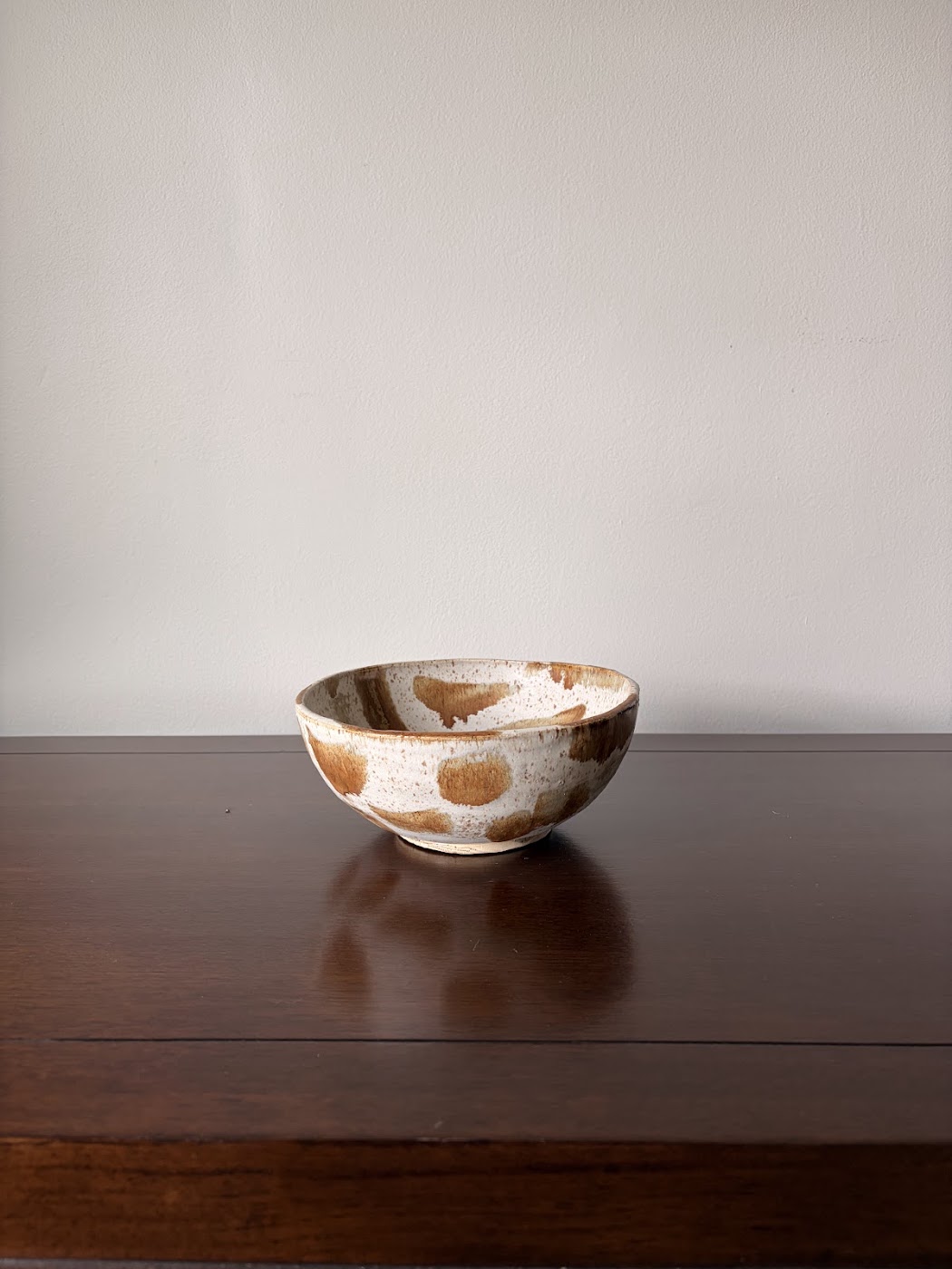 Ceramic serving bowl with ochre brushstrokes on speckled cream clay